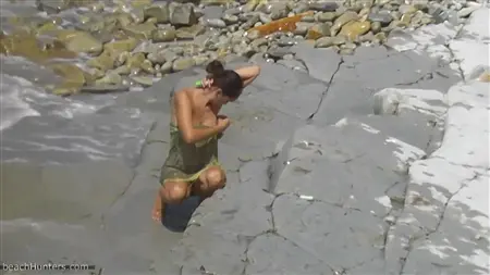 Девушка в прозрачном парео бродит по берегу реки