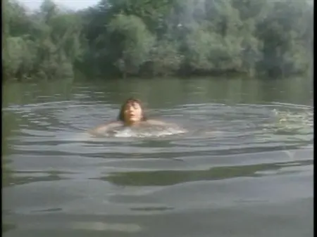 Игривая девица плавает в речке голышом