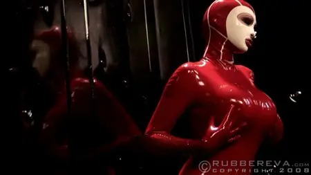 Игривая сучка в красном латексе сексуально позирует перед зеркалом