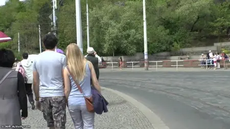 Люди рассматривают гуляющую по городу обнаженную девушку