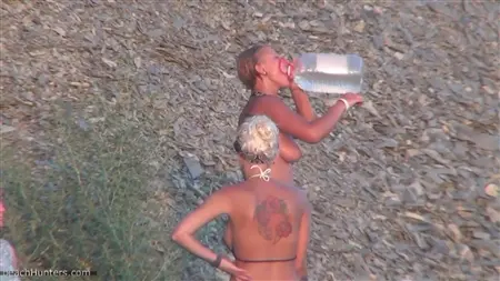 Обнаженные девушки моются под душем на общественном пляже