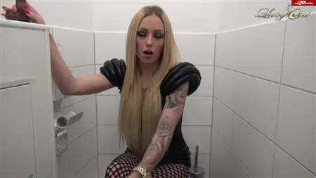 Татуированная блондинка упражняется с резиновым членом в туалете